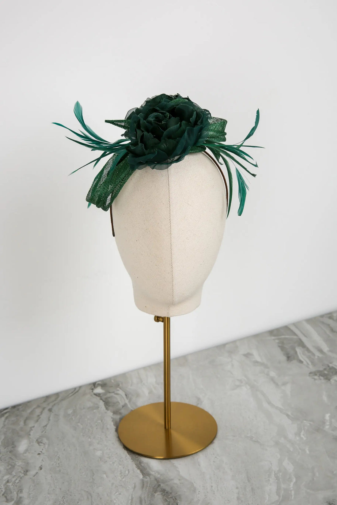Green floral headpiece on a mannequin head against a white background