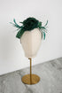 Green floral headpiece on a mannequin head against a white background
