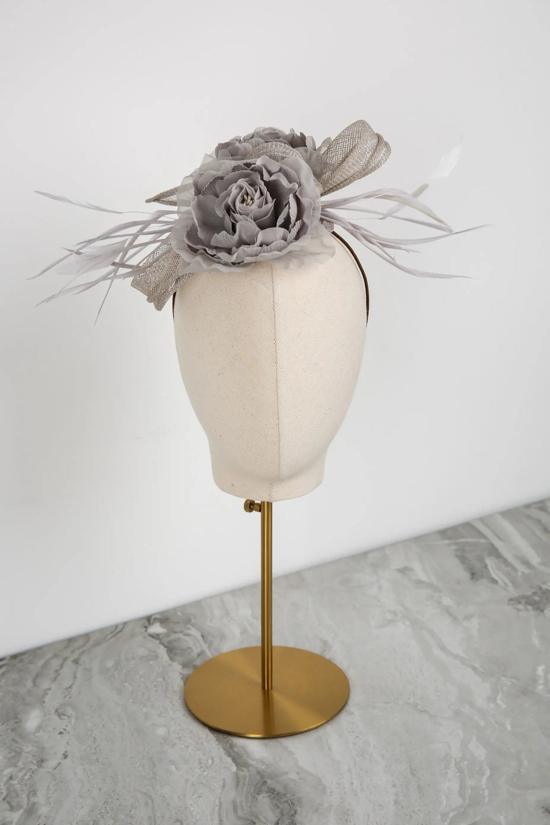 Silver floral headpiece on a mannequin head against a white background