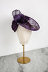 Purple decorative hat on a mannequin head against a white background