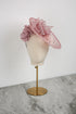 Pink floral headpiece on a mannequin head against a white background