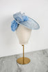 Light blue decorative hat on a mannequin head against a white background