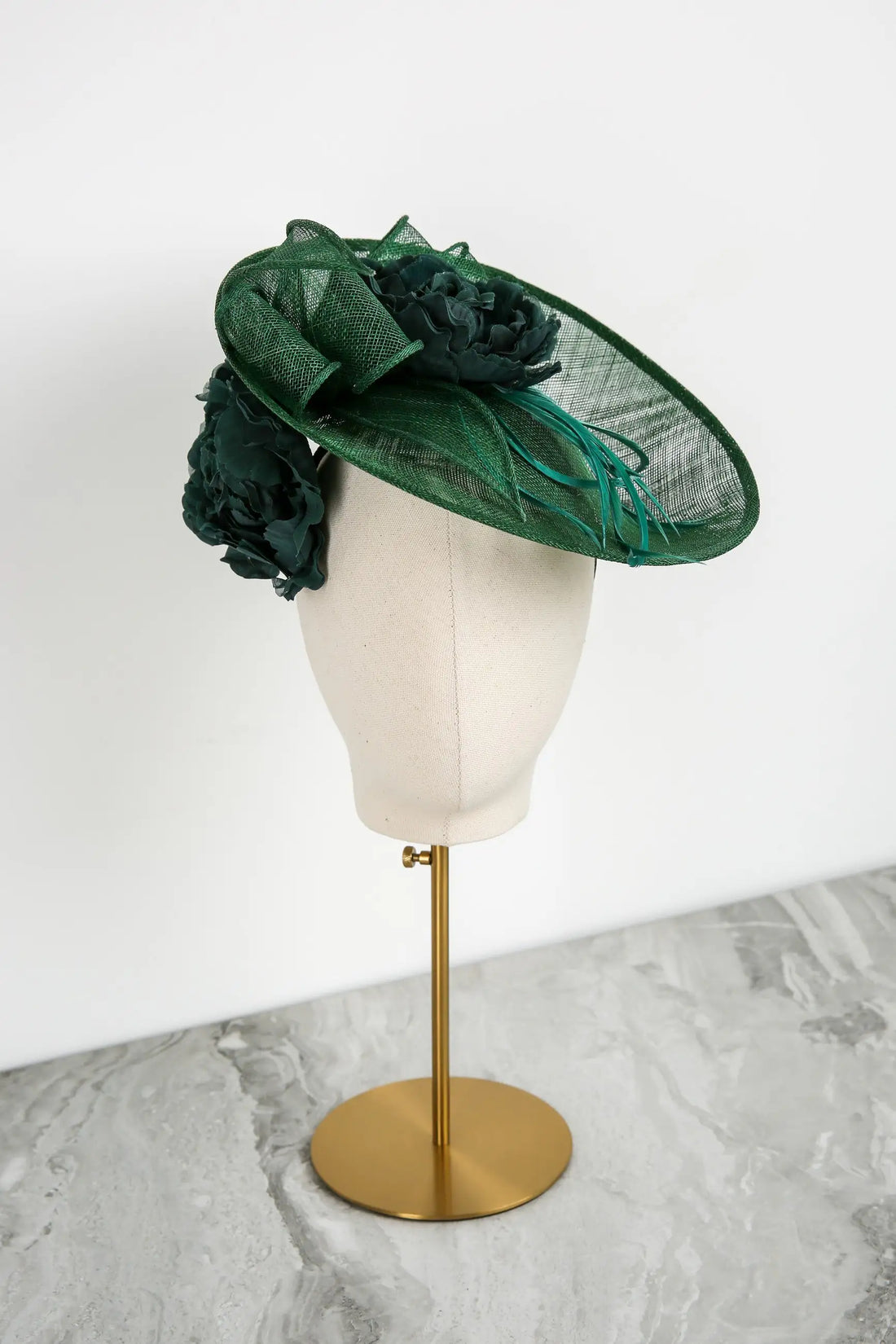 Green decorative hat on a mannequin head against a white background