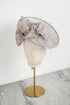 Silver decorative hat on a mannequin head against a white background
