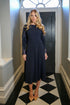 Woman wearing a Dark Navy long sleeved dress.