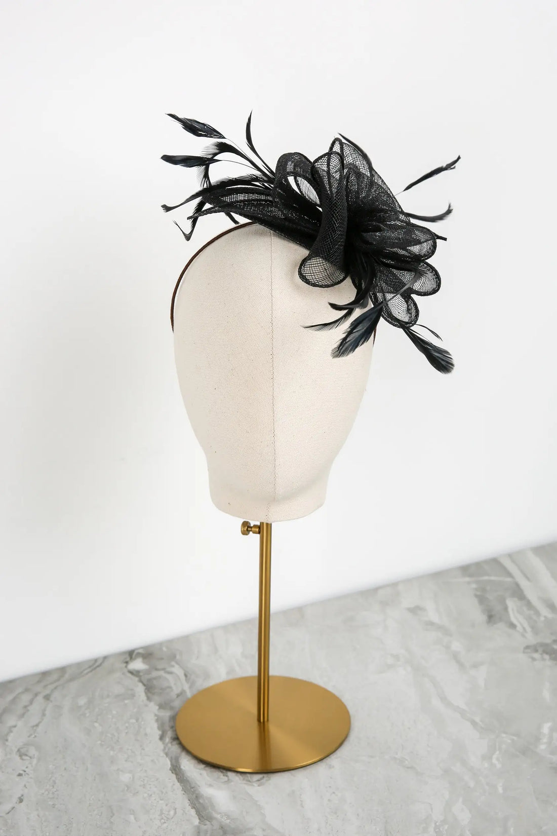 Black decorative headpiece on a mannequin head with a white background