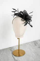 Black decorative headpiece on a mannequin head with a white background
