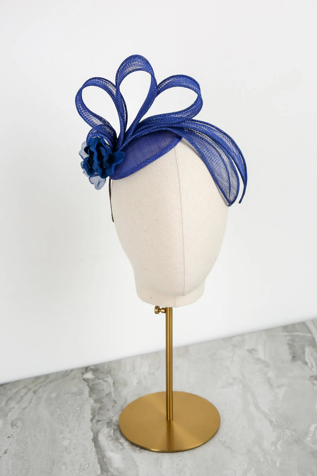 Blue decorative headpiece on a mannequin head against a white background